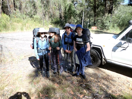 Four young people are standing with packs on ready to start walking on there Silver Bushwalking Award journey