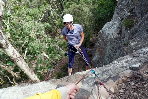 A single abseiling person is going down a cliff on the Wine Country Abseiling Tour