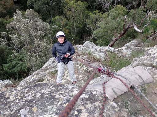 A very nervous person is abseiling down a cliff during the Lake Macquarie Abseiling Adventure