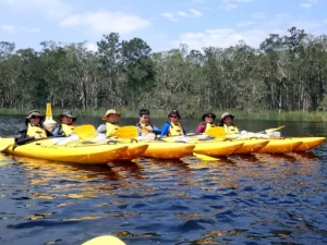 A group of Kayaks are sitting together with paddlers having a rest during lessons on the Bronze Kayaking Award Journey 