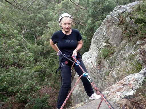 A confident lady having over the cliff during her visit to the Hunter Valley Abseiling Adventure