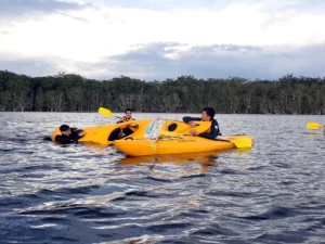 A kayaker is in the water with his Kayak tipped over learning to do rescue procedure during a Bronze Kayaking Award Journey