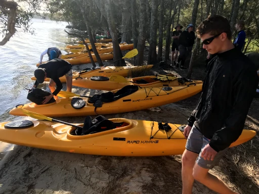 Kayaks on the shore getting loaded with camp gear during the Silver Kayaking Award Journey