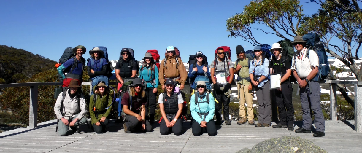 A group of students are being photographed with packs on at the start of the Mount Kosciuszko to Bass Strait epic hike and paddle.