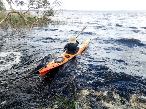 A kayaker paddles out into some waves during the Myall Lakes Kayak Adventure
